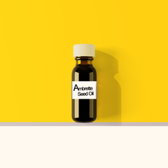 Pure Ambrette Seed Oil in a bottle with seeds and flowers in the background.